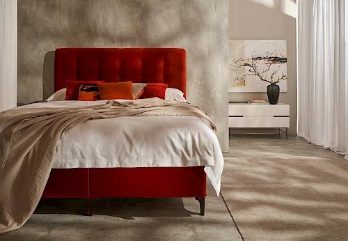 Red Vispring bed with draped throw