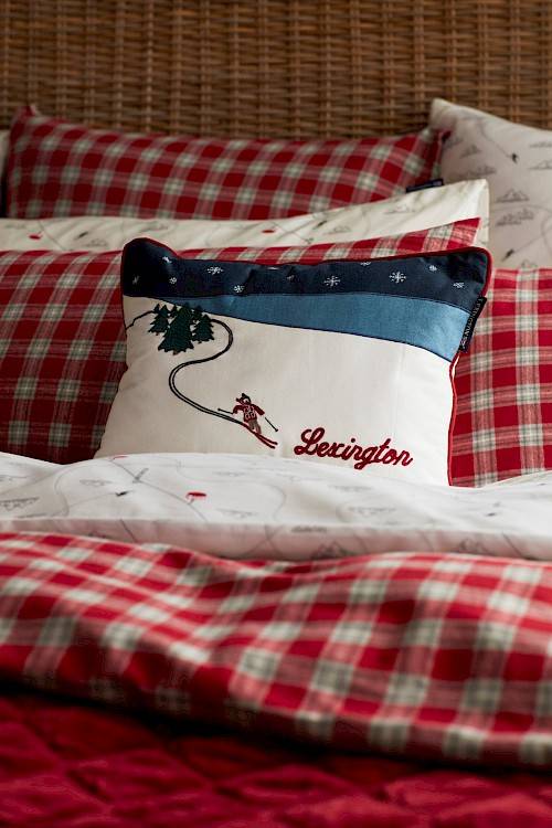 Styled bed with ski-themed decorative cushion